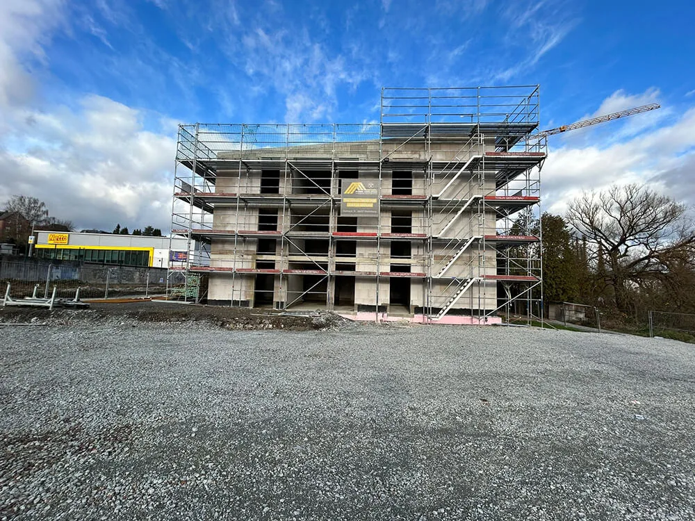 Eingerüsteter Neubau in Elz unter blauem Himmel