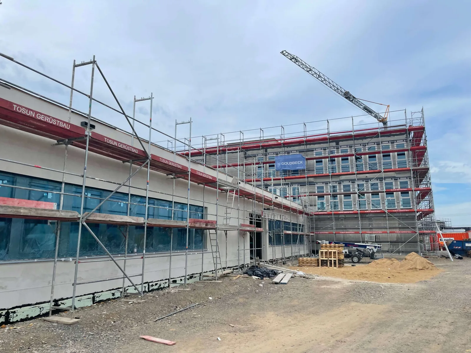 Gewerbeneubau in Limburg mit umlaufendem Fassadengerüst und Kran